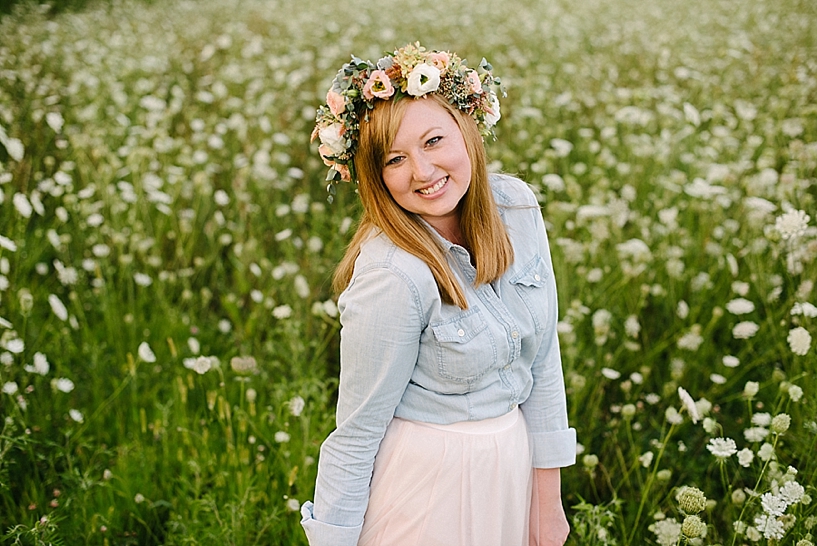 Redheaded woman wearing floral crown and tulle skirt standing in a field