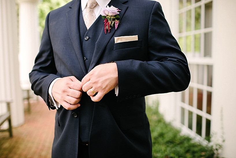 groom buttoning suit jacket
