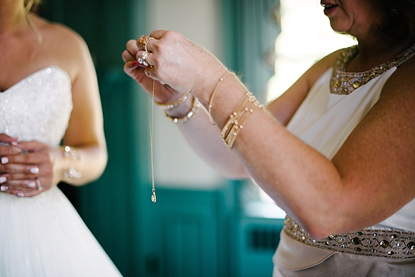 mother of the bride holding her necklace