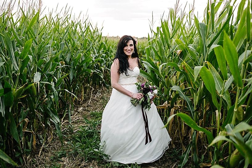 bride standing in corn maze