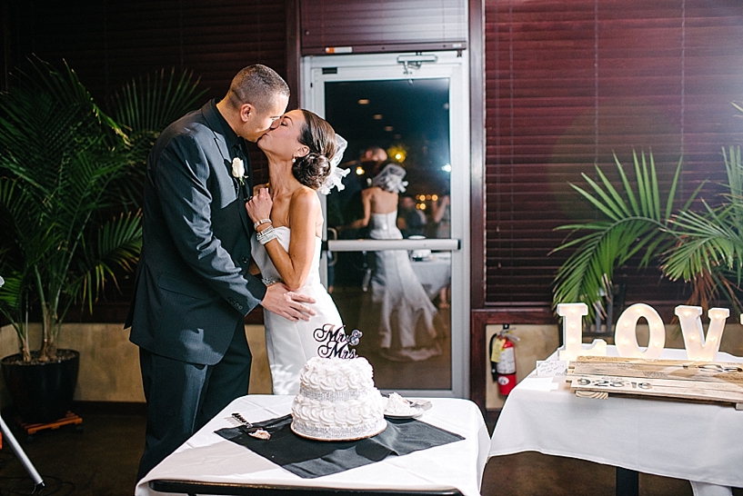 bride and groom kissing after cutting wedding cake