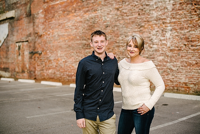 mom and son standing in front of brick wall
