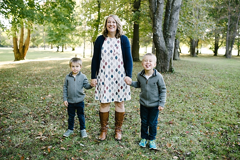 mom in Lularoe dress with leaves on it holding hands with her sons