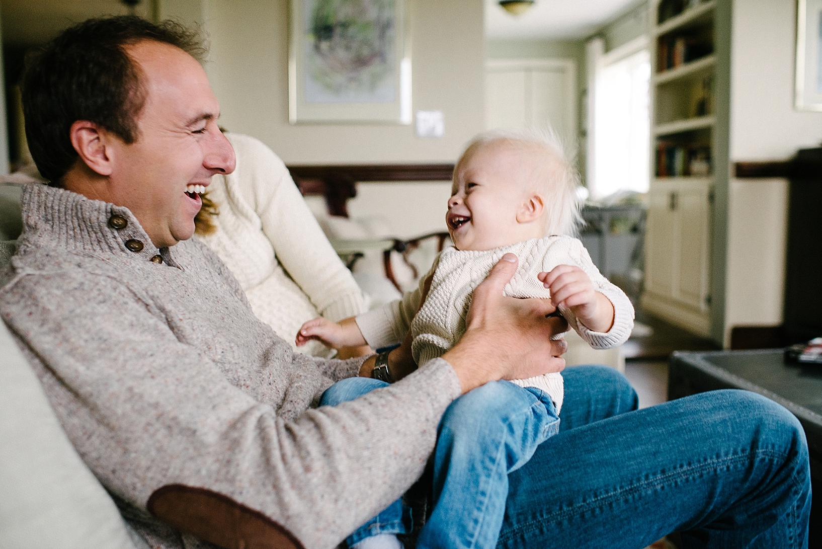 father and son laughing on living room couch