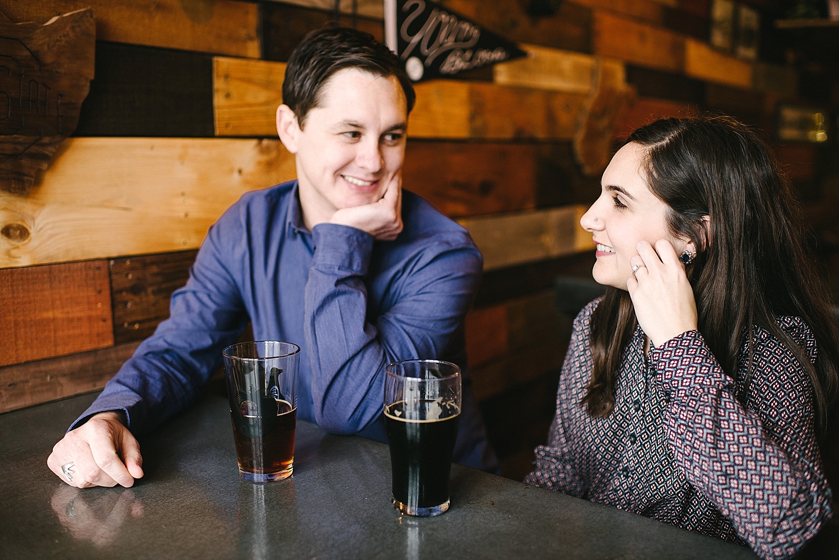 couple sitting at craft brewery talking and laughing at bar