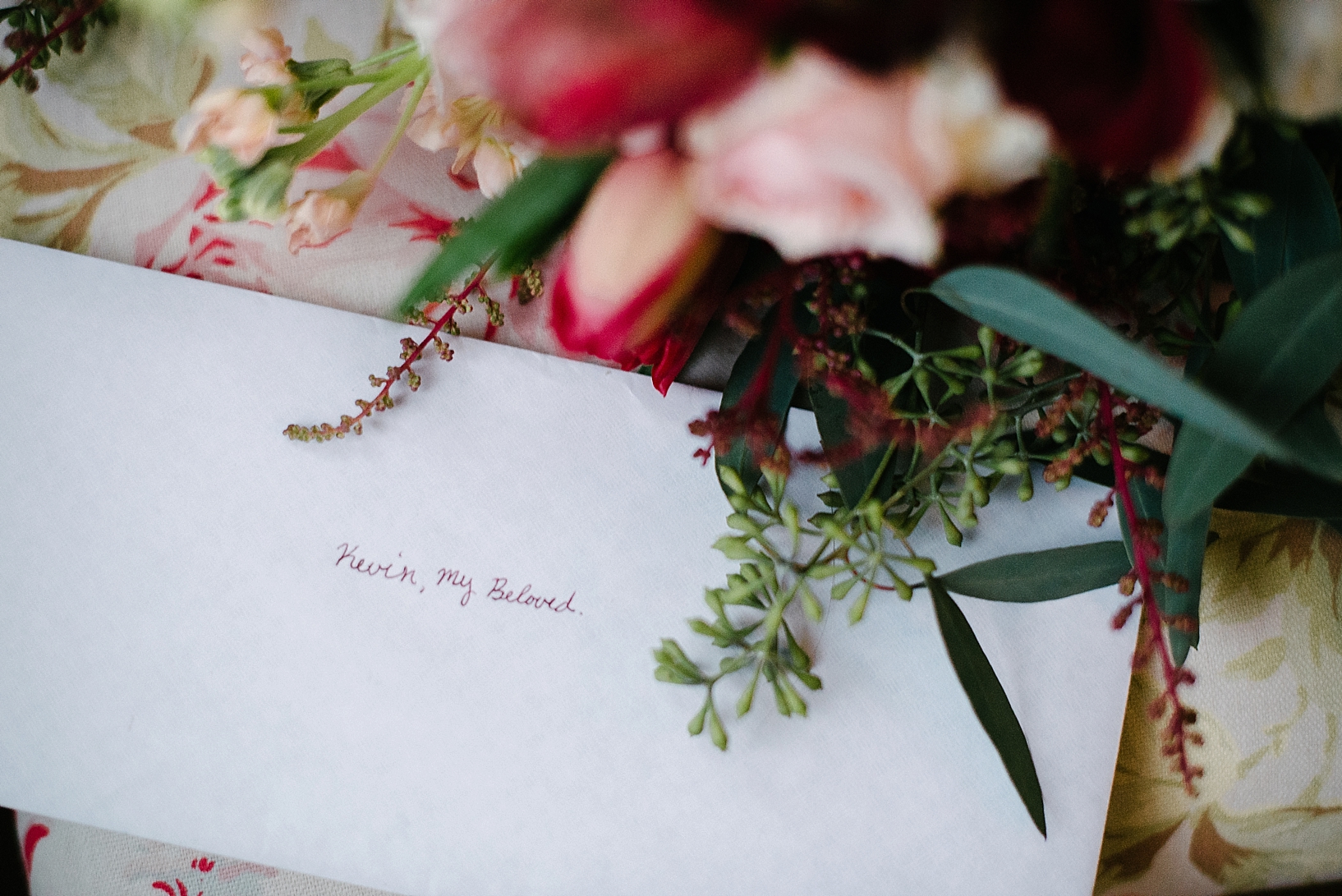 letter to groom in white envelope next to bridal bouquet