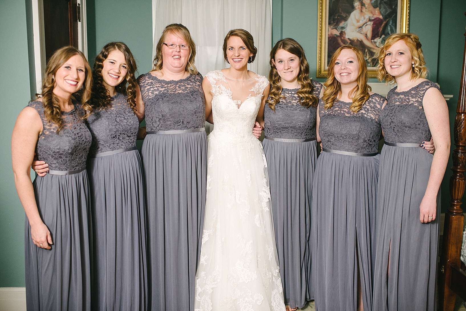 bride and bridesmaids in gray lace dresses standing together