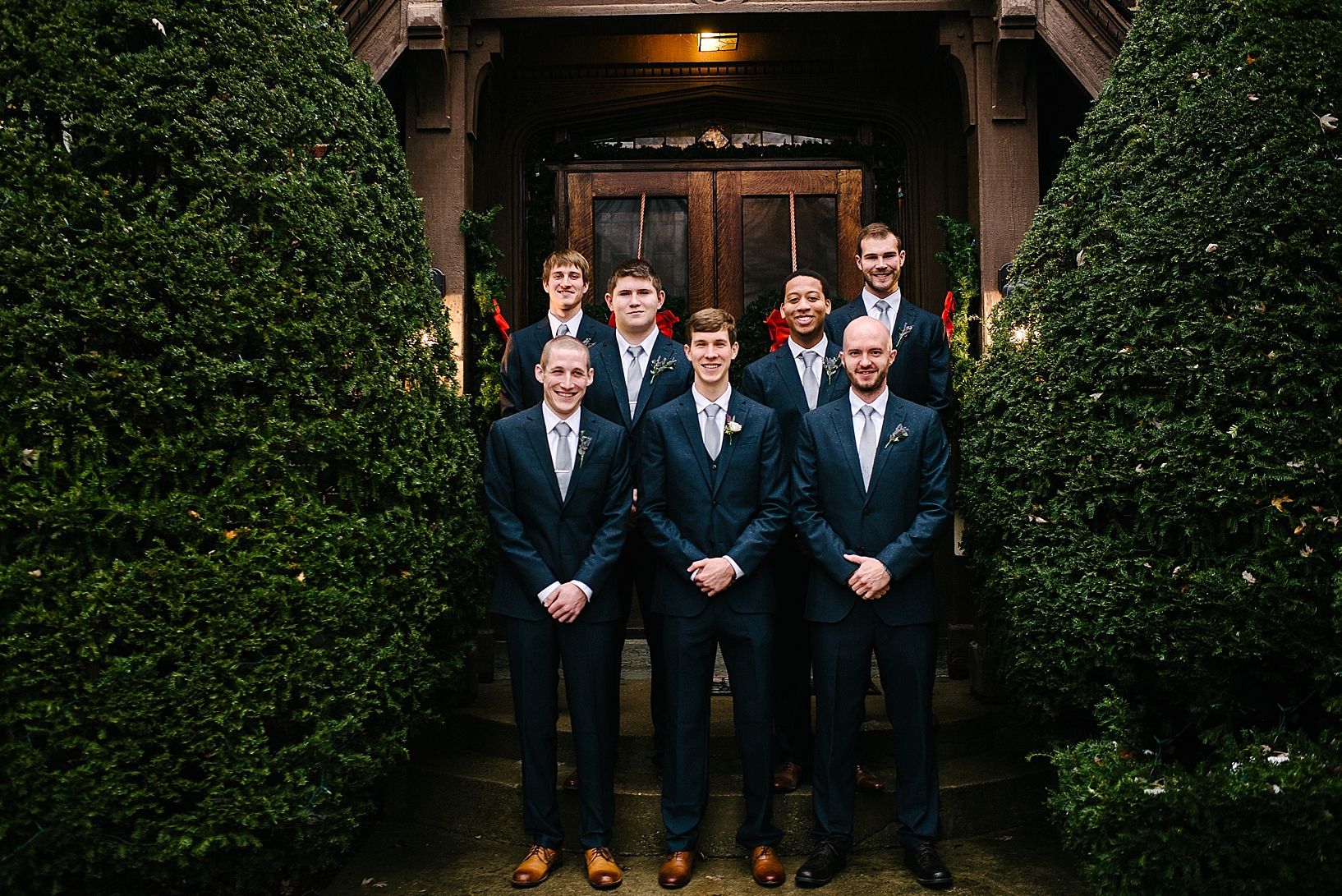 groomsmen in navy suits standing in front of English Manor Bed & Breakfast