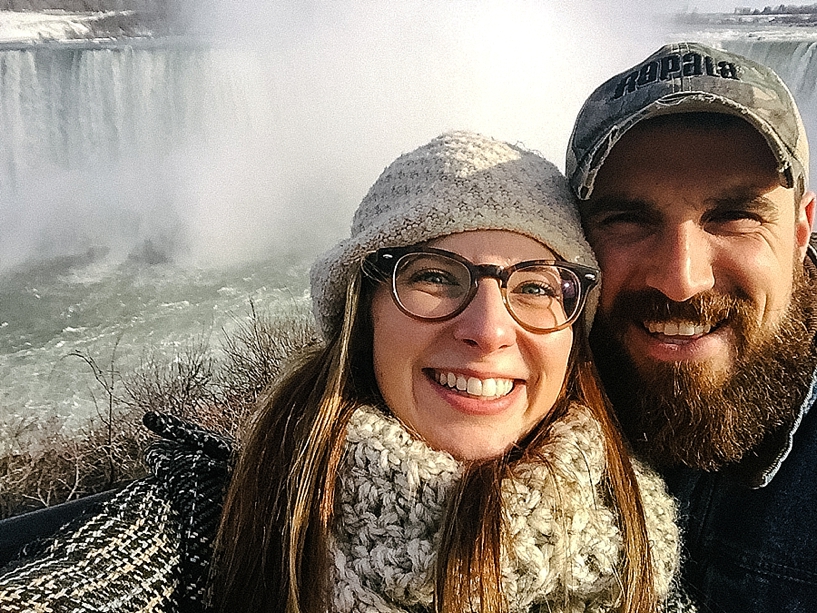 couple standing in front of Niagara Falls in winter
