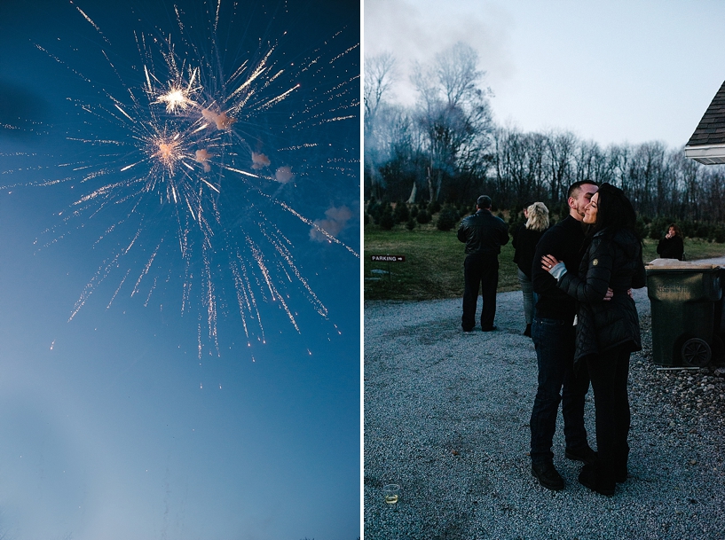 newly engaged couple kisses with fireworks going off in the distance