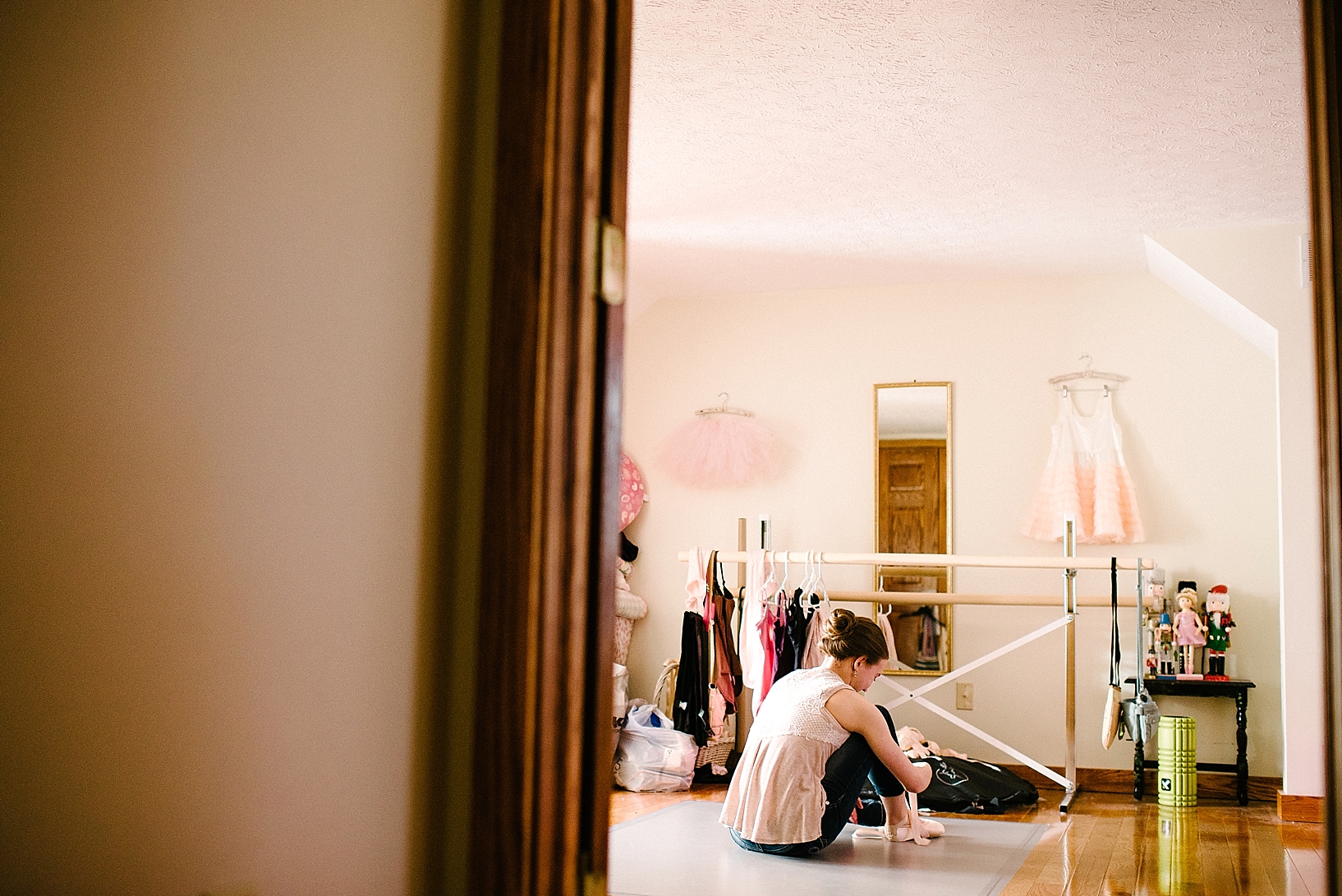 teen girl in bedroom lacing up ballet slippers