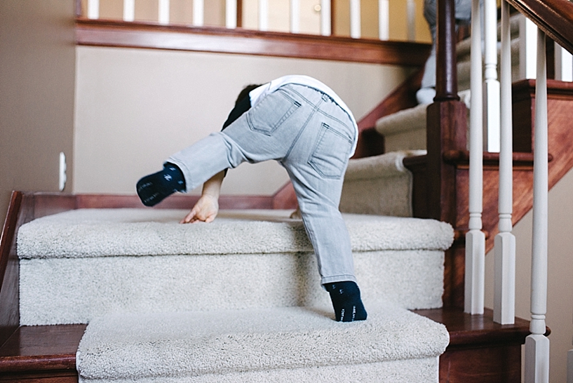 toddler boy climbing up staircase