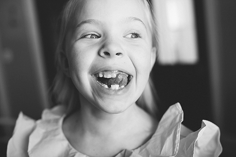 little girl wiggling her tongue between gaps in teeth