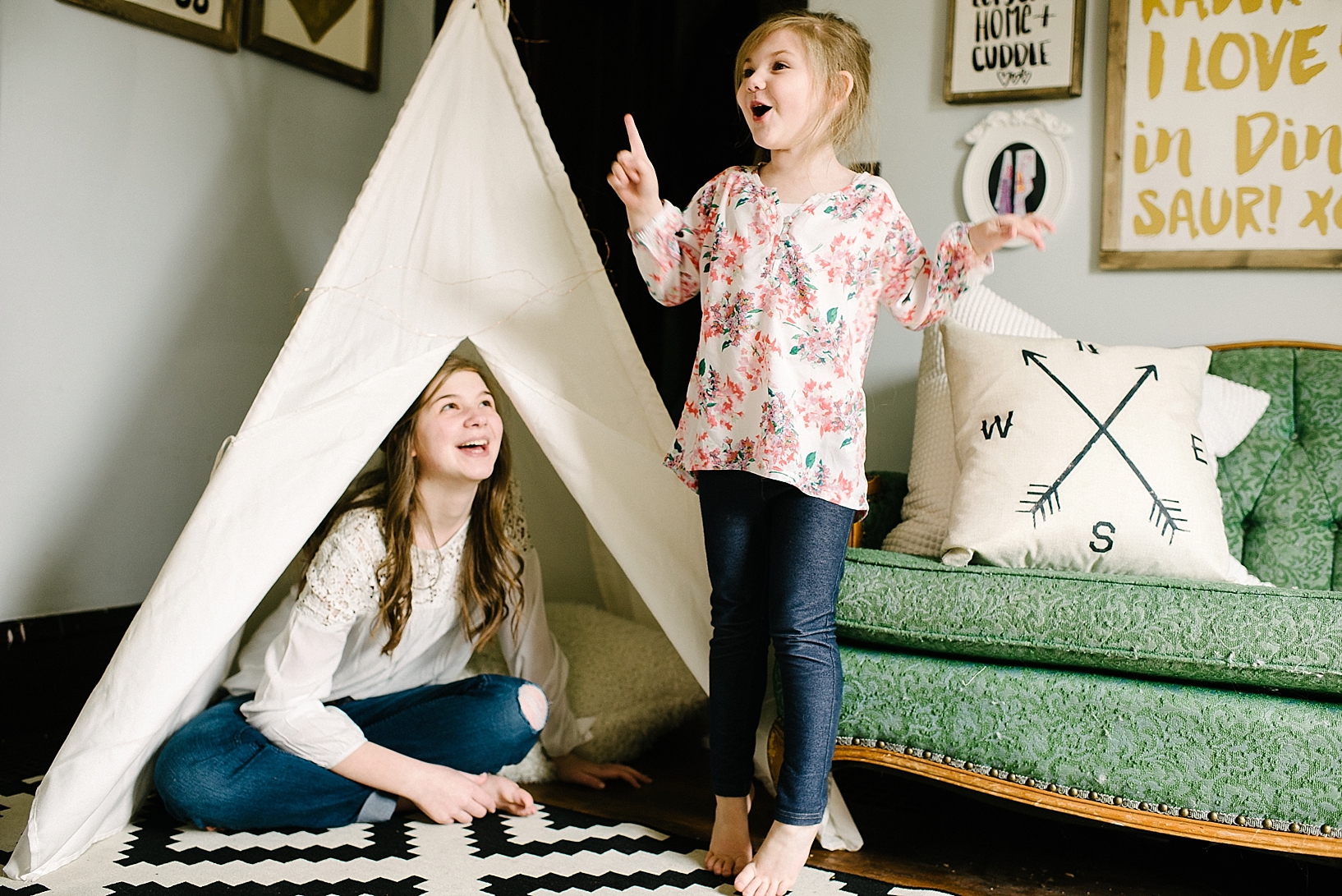 sisters playing in teepee in eclectic living room