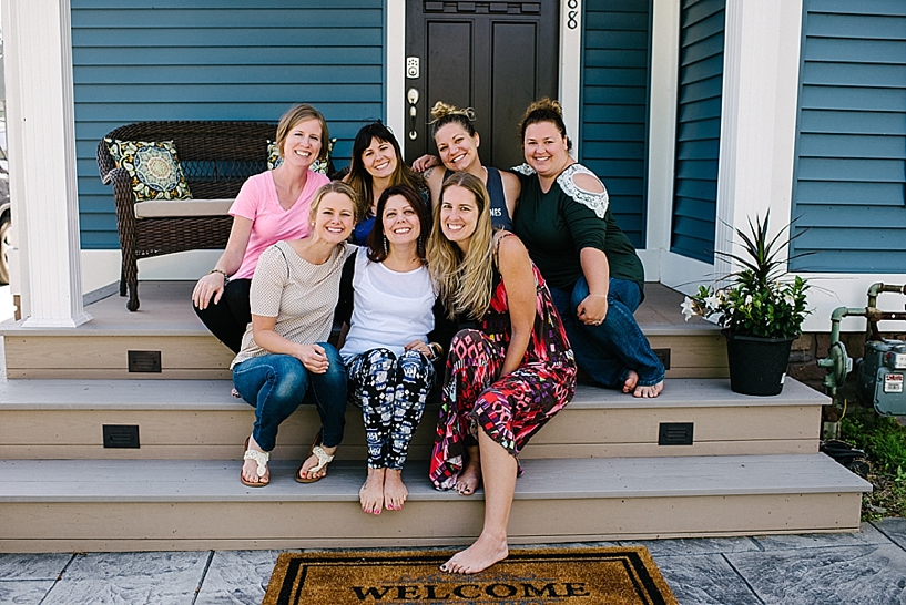 group of women sitting on steps of front porch