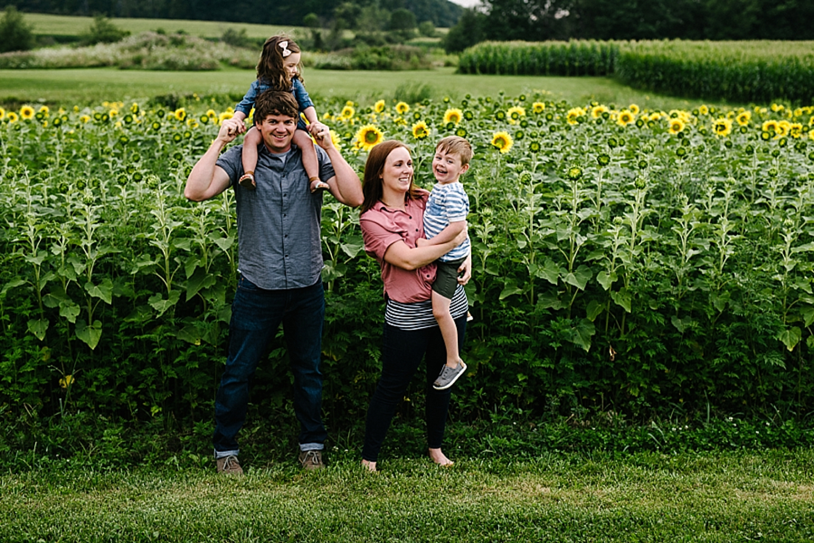 family standing in front of sunflower field