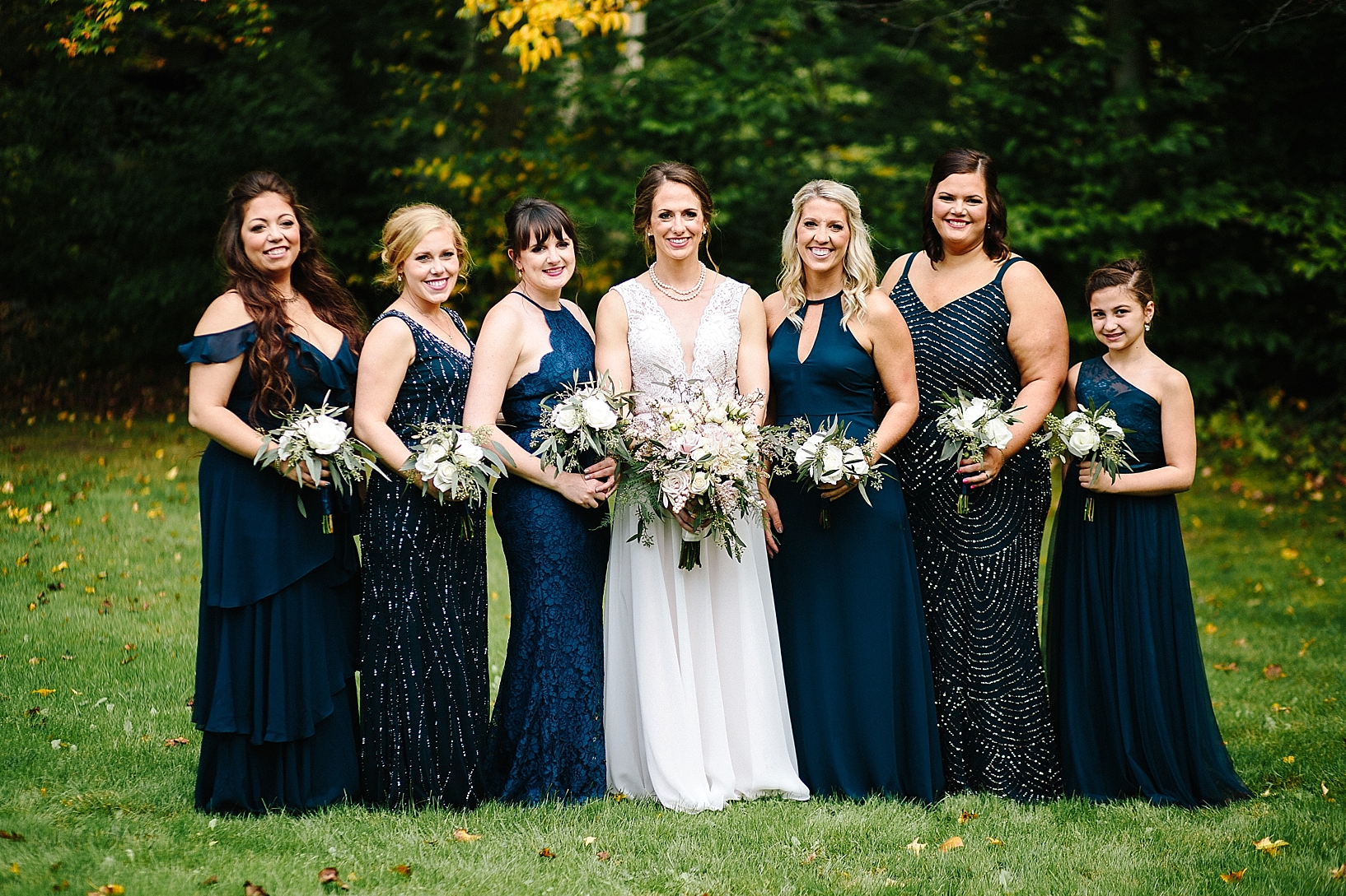 bridesmaids wearing navy gowns and bride wearing Taryn Gown BHLDN