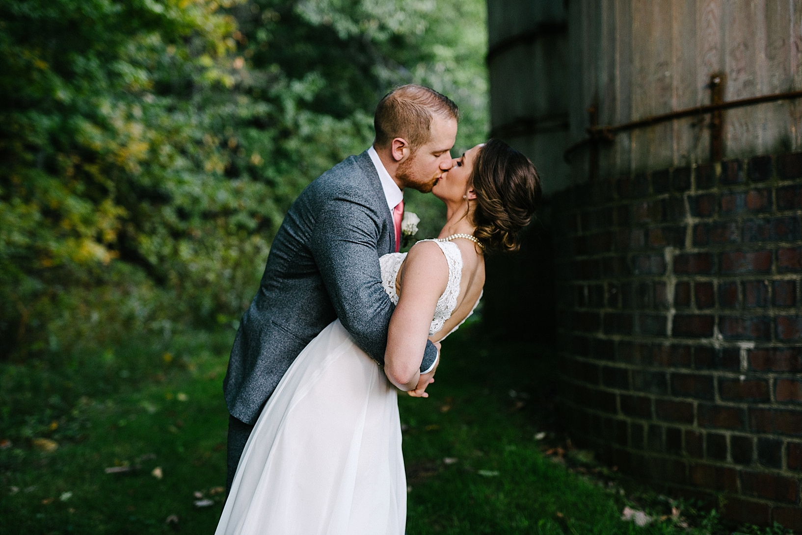 bride and groom kissing next to silo at Stone Ledge Farm