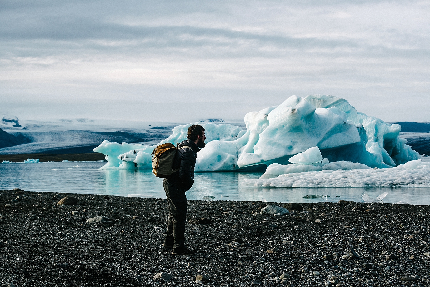 man standing on beach looking at icebergs Jokulsarlon Iceland