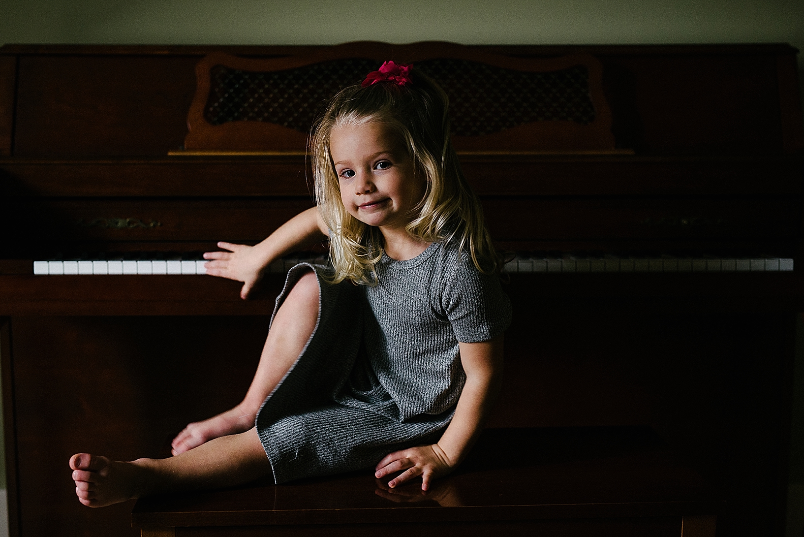 young girl sitting at piano in home
