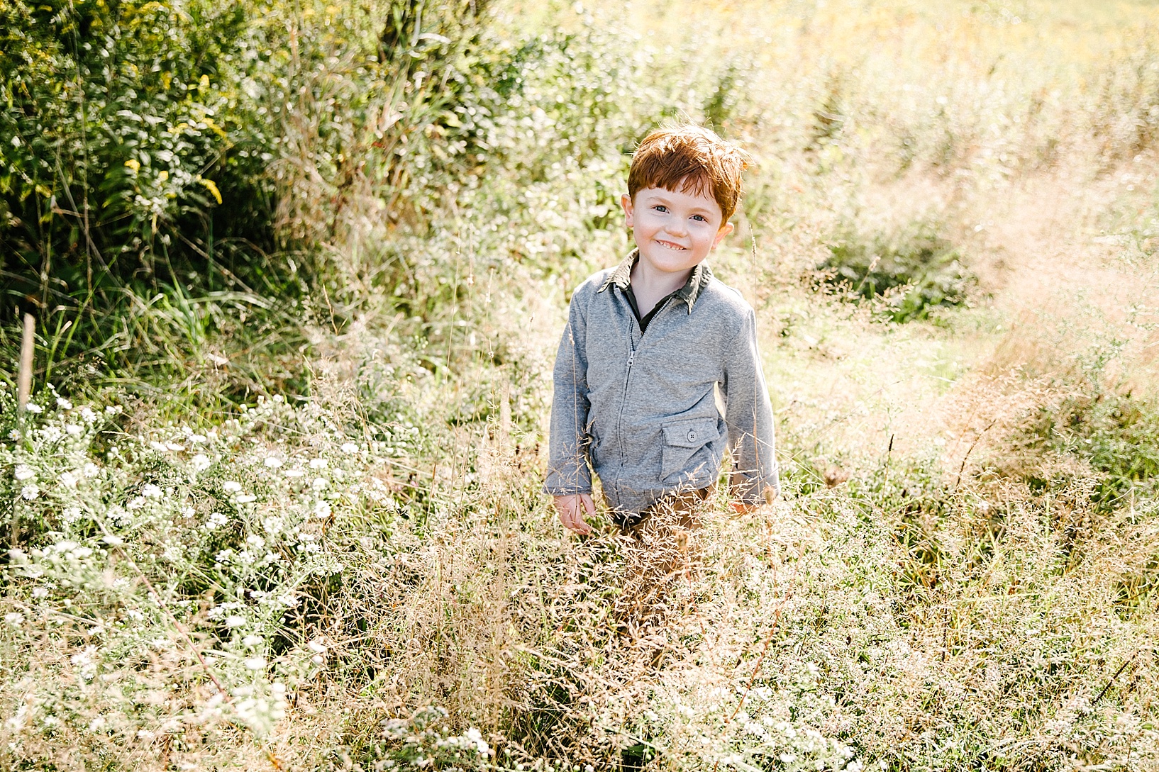 little boy standing in field