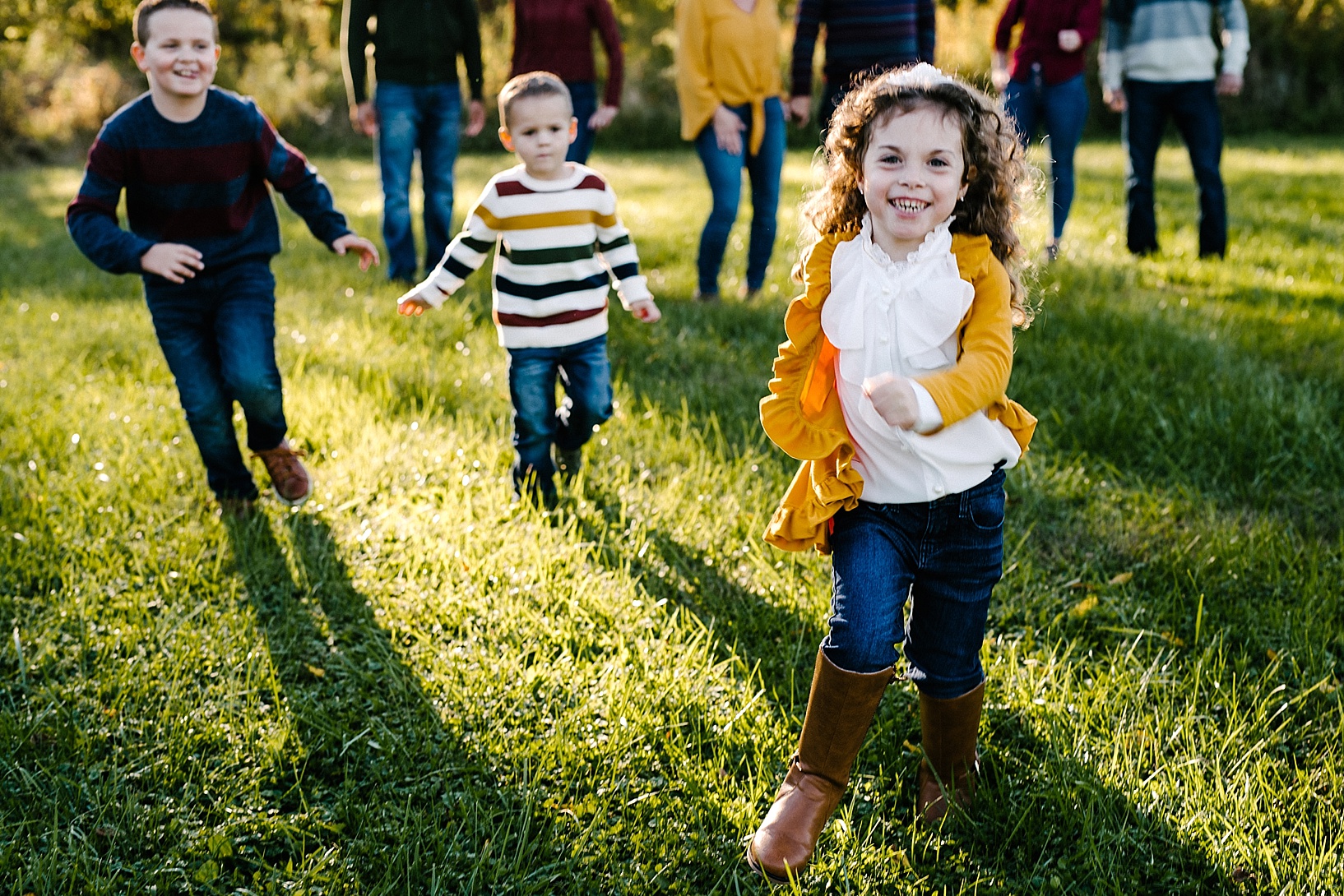 kids running across field during fall family photos