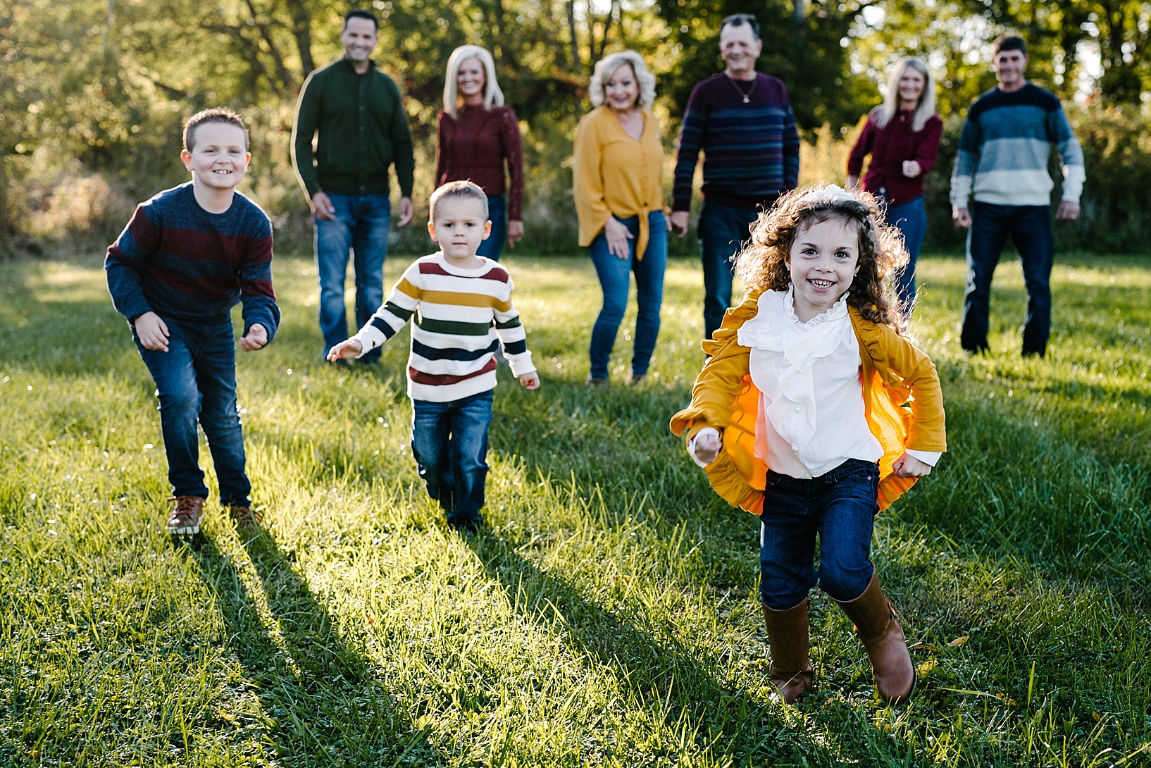 kids laughing and running while family stands behind them smiling