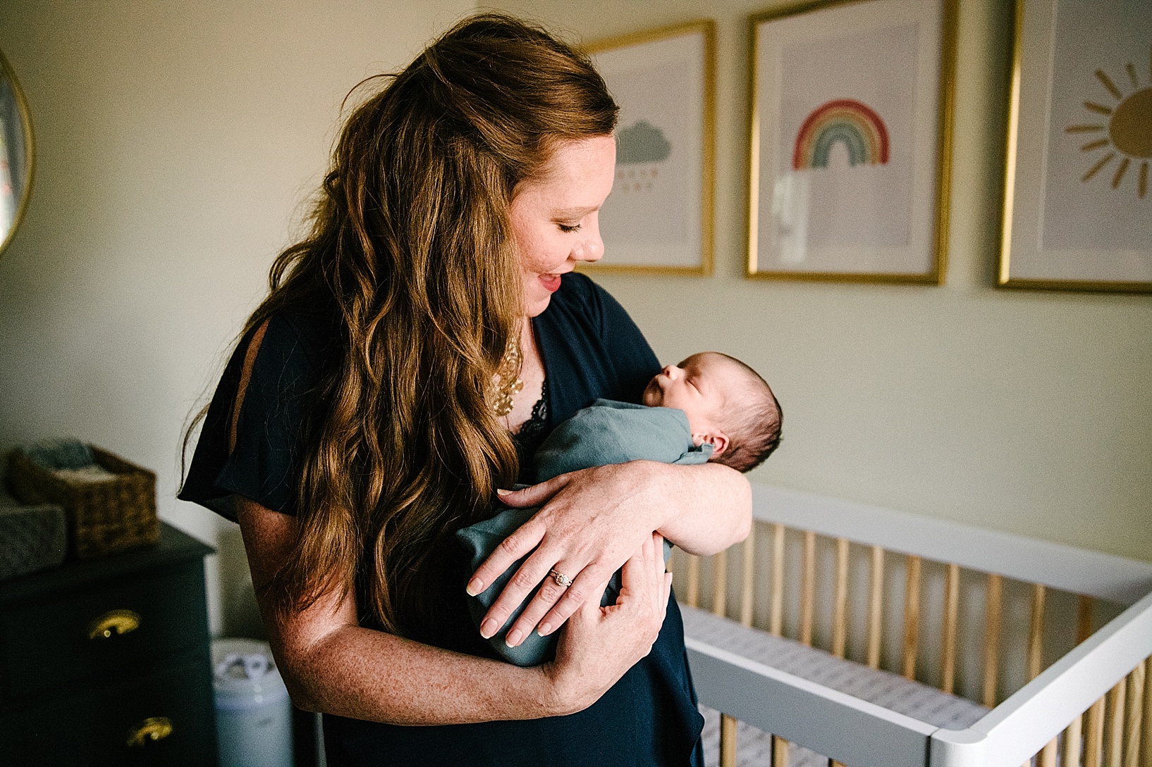 mother holding newborn baby in nursery