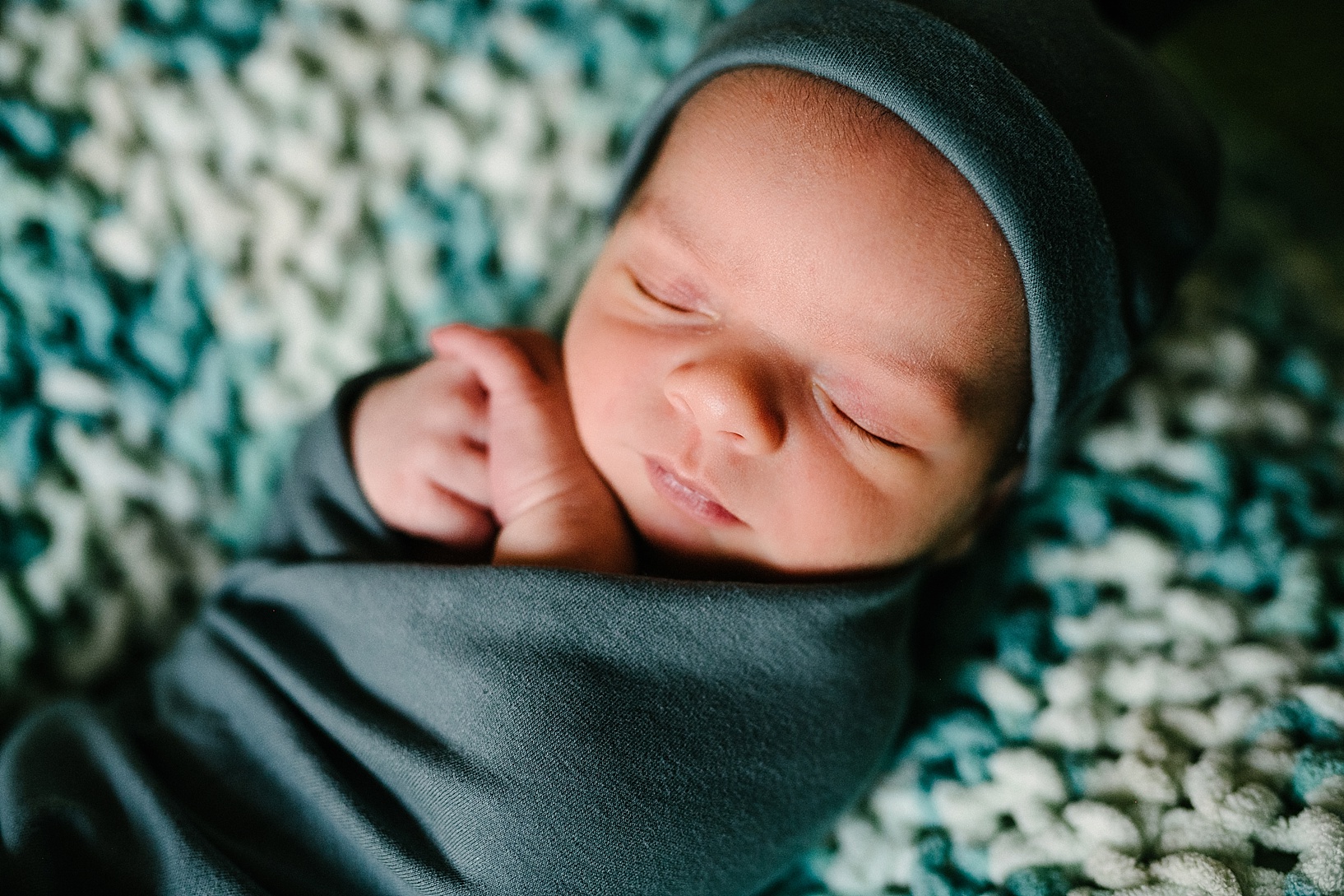 newborn baby swaddled in teall blanket