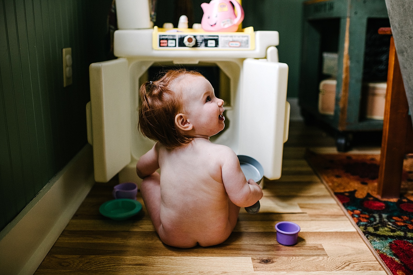 naked toddler playing with little tikes play kitchen