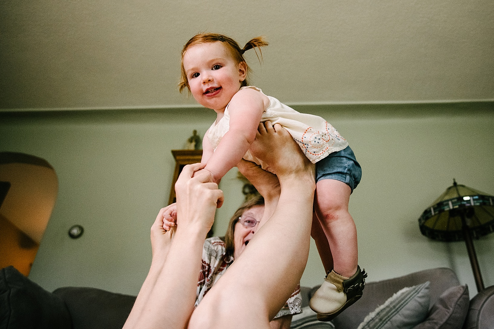 little girl playing airplane on mom's feet