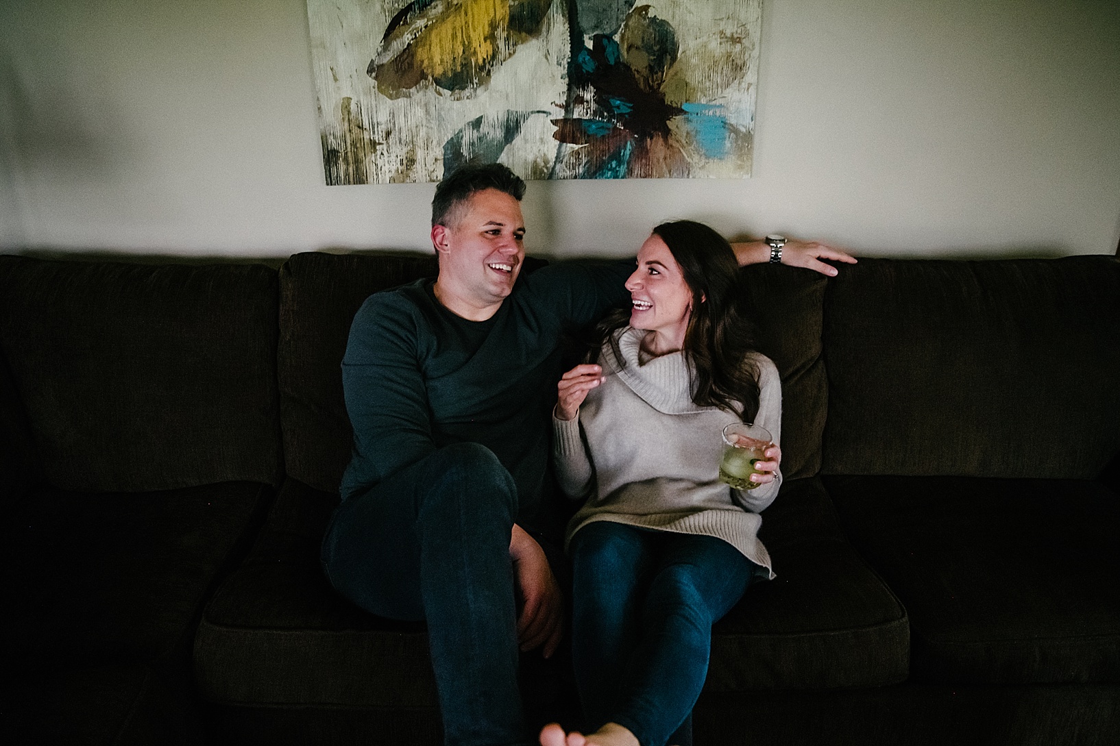 couple sitting on couch drinking cocktail and talking