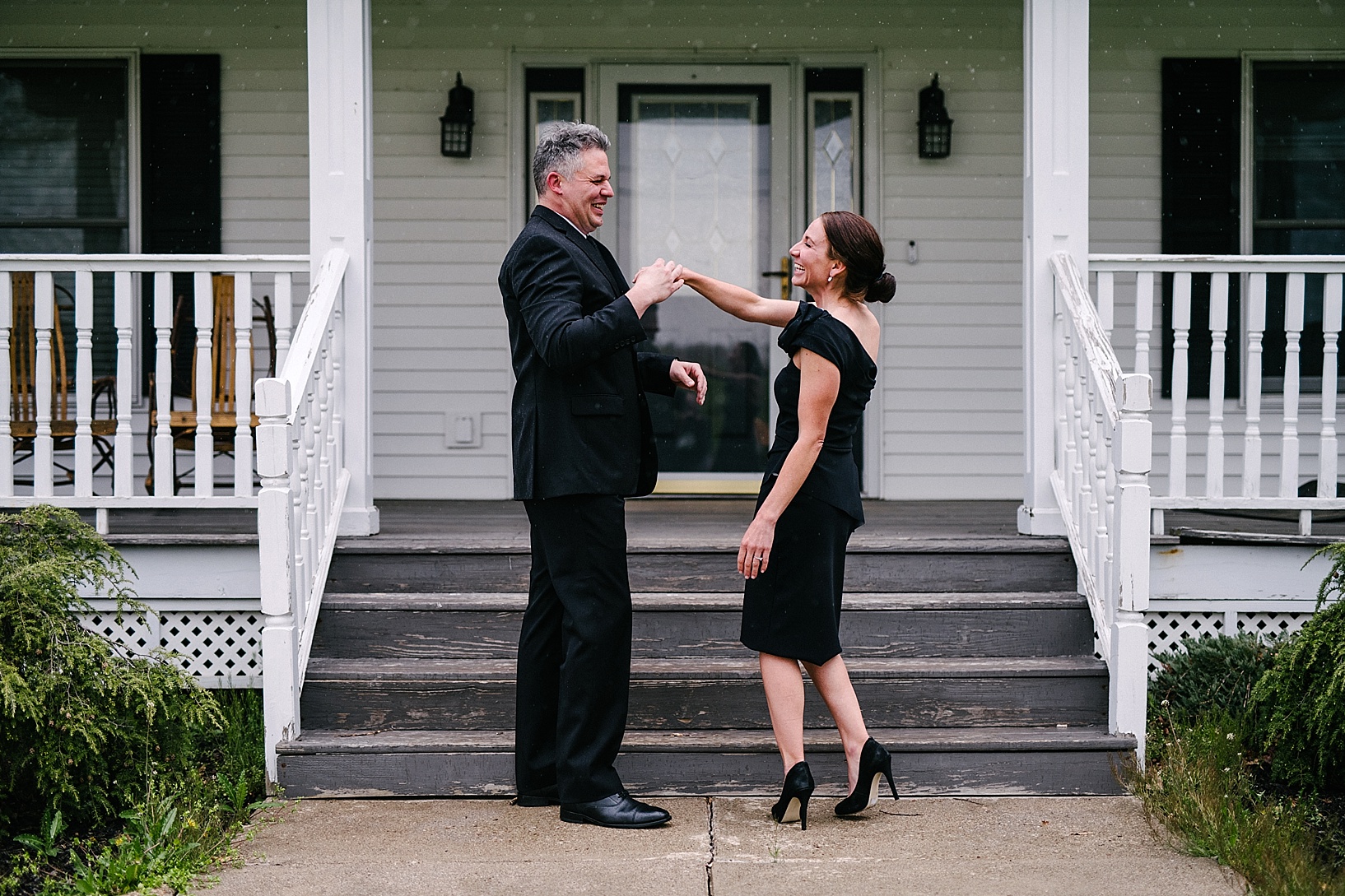 couple in formal attire dancing in front of porch
