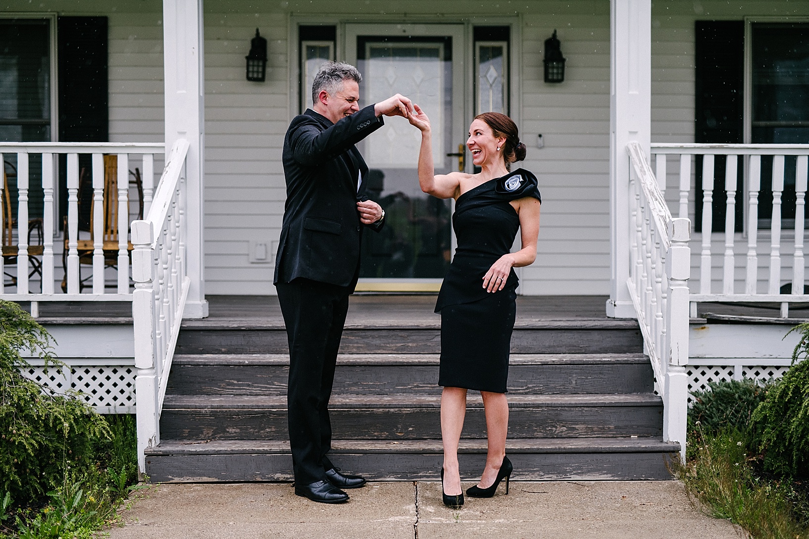couple in formal attire dancing in front of porch
