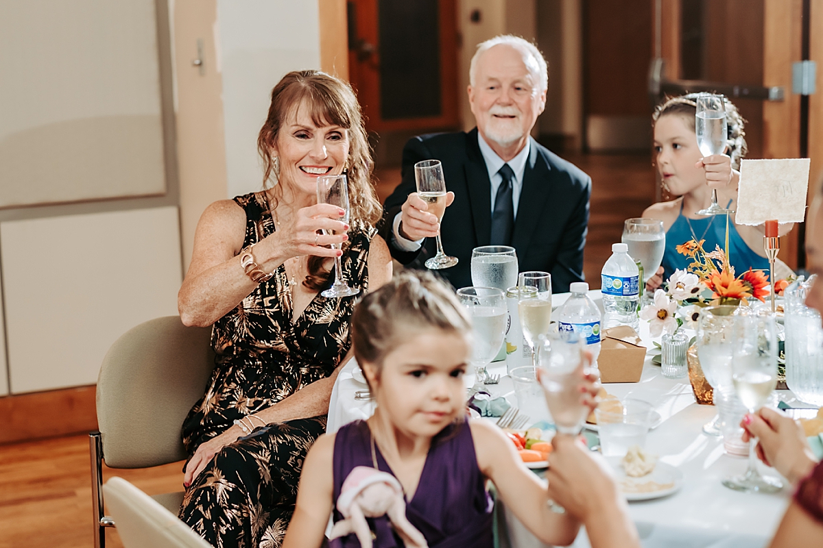 groom's parents raising glasses during wedding toast