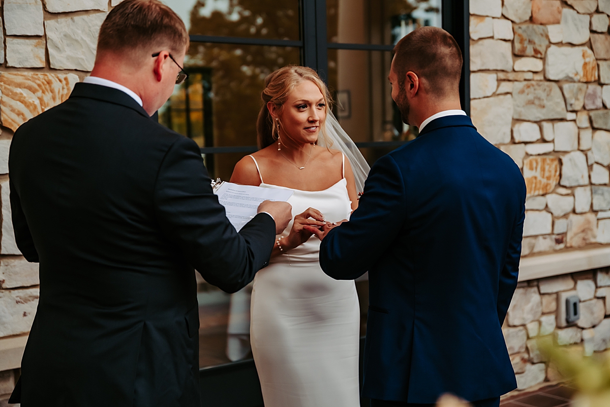 bride and groom exchanging rings during wedding ceremony