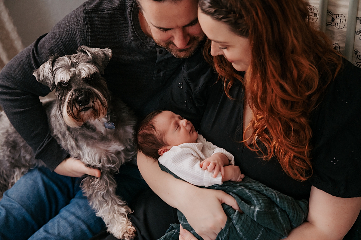 newborn baby with parents and dog