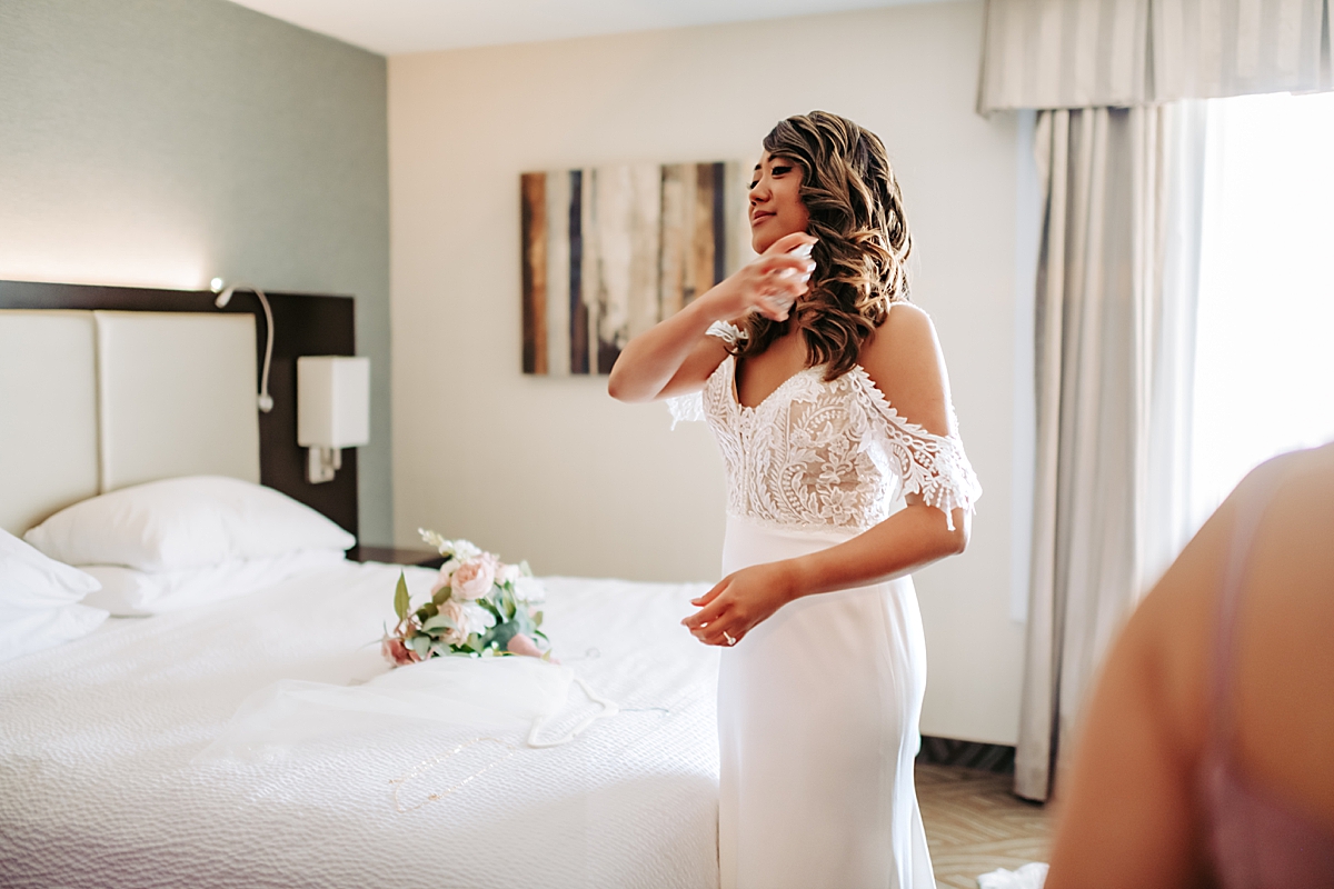 bride spraying perfume on her