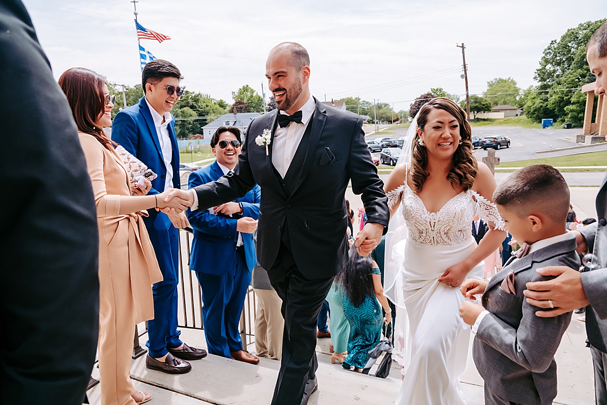 bride and groom greeting guests after wedding ceremony